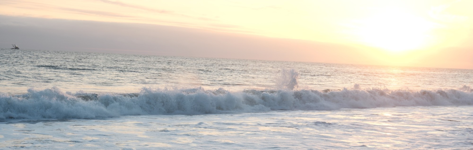 Waves rolling in under a Malibu sunset